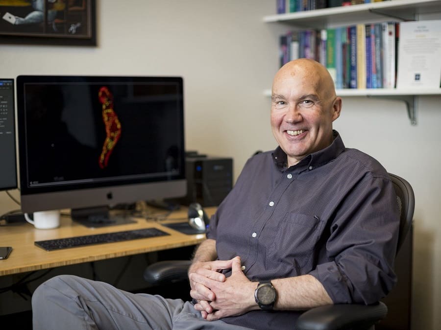 Professor Scott Earley, the University of Nevada, Reno Outstanding Researcher for 2022, sits at his office desk.
