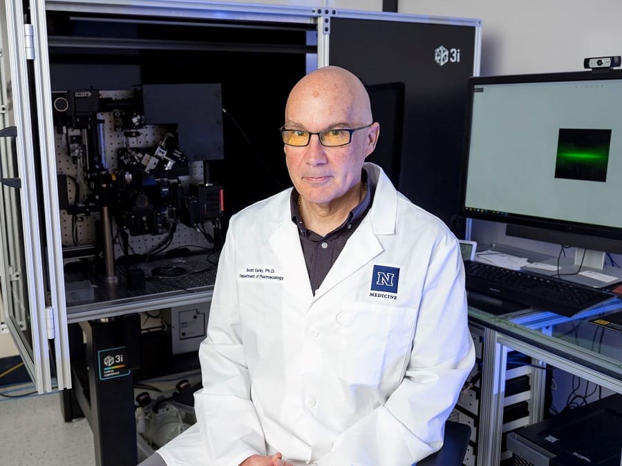 Scott Earley, Ph.D., sits at a lattice light sheet microscope.