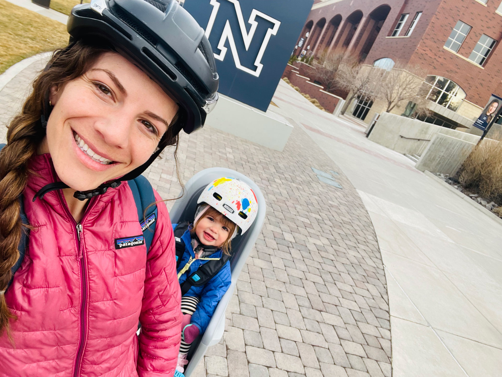 Jennifer Kent and her daughter on a bike on campus.