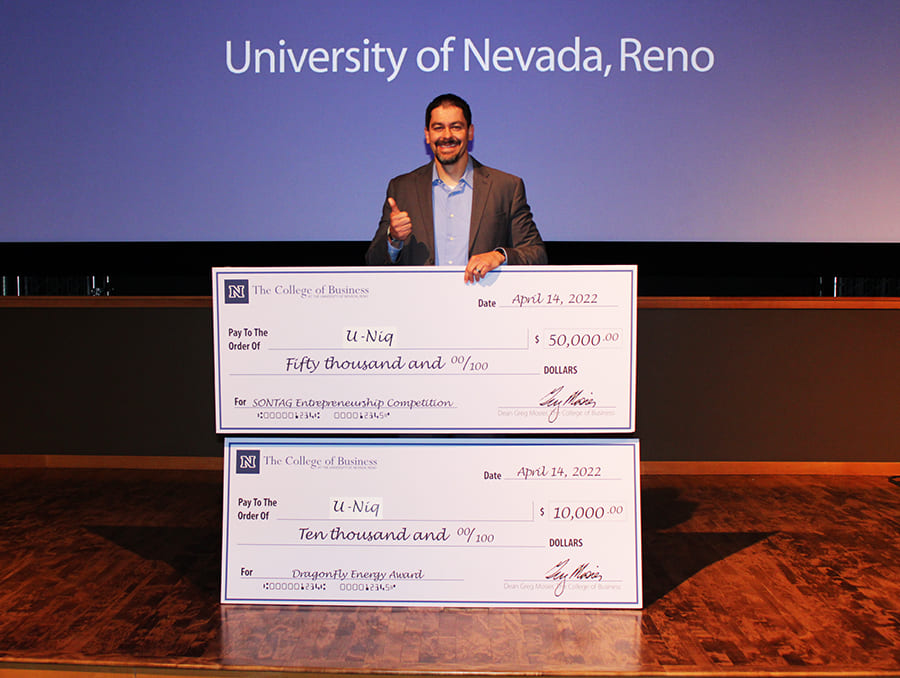 Perm Singh, the 2022 Sontag Entrepreneurship Competition, holding his $50,000 Sontag Award big check and $10,000 Dragonfly Energy Innovation Award big check.