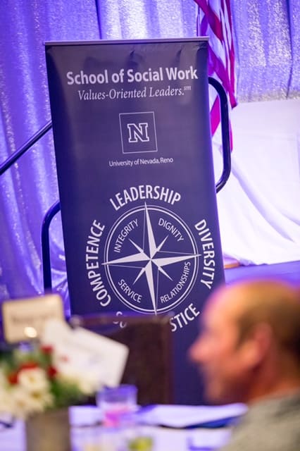 The School of Social Work compass rose logo on a sign at the event