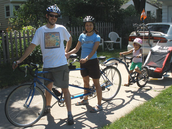 Tom Albright, his wife and daughter on a triple bike with a trailer