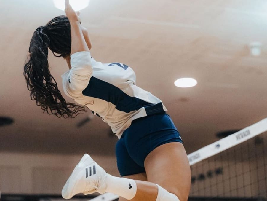 Kyla Waiters jumping to hit a volleyball during a game
