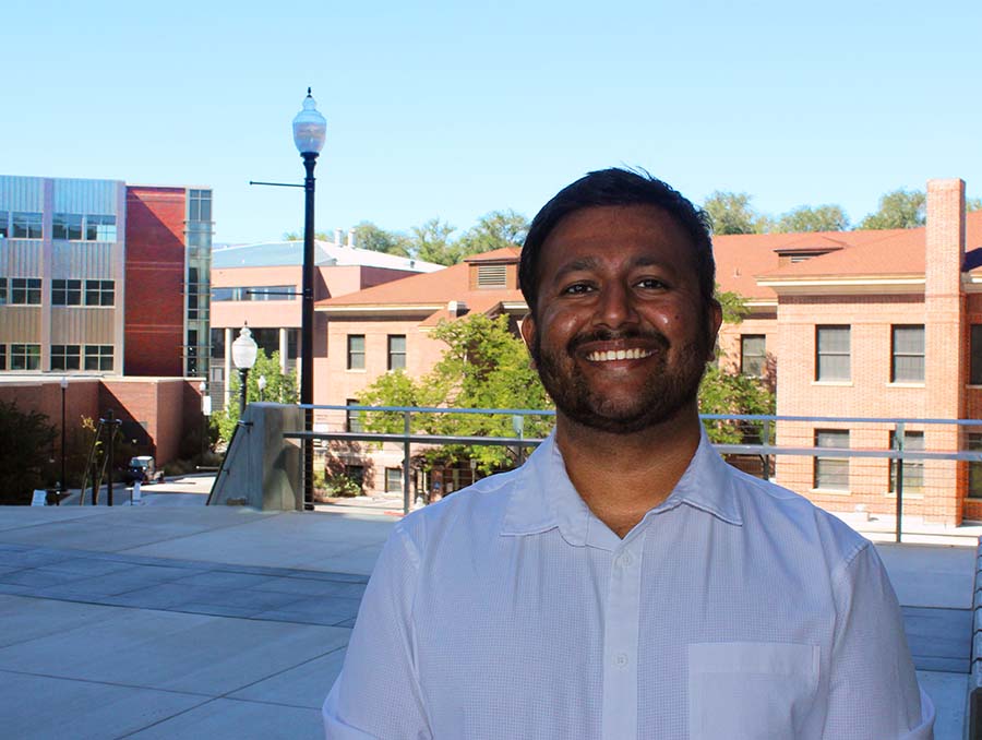 Aditya Nair portrayed from the chest-up, standing outside in front of a building.