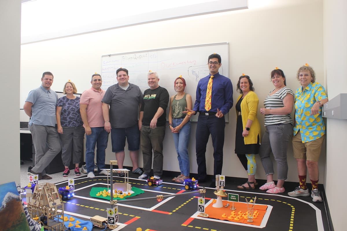 Photo of a group of teachers posing together at the front of a classroom.