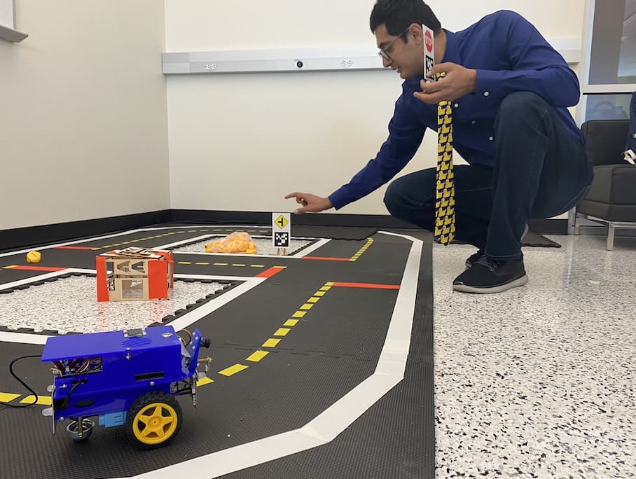 Man hovering over a toy-size race track meant for rubber ducks.