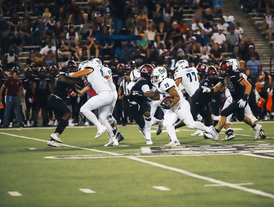 Toa Taua carries the ball in game at New Mexico State University. 