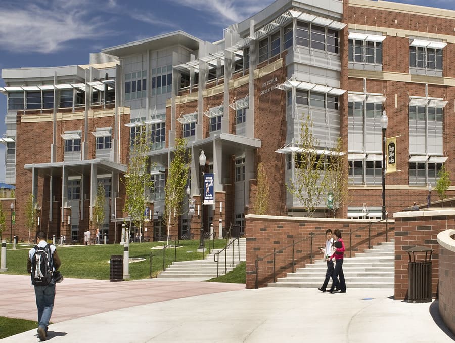 Photo of a building with a few students walking through the frame. 