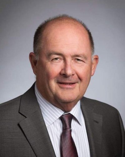 Dr. Richard Bartholet poses in front of a light gray background