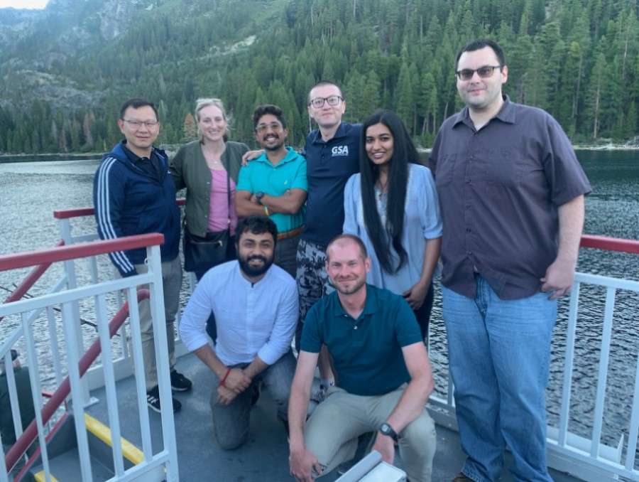 A group of PhD students from the University of Nevada, Reno, stand on a boat together.