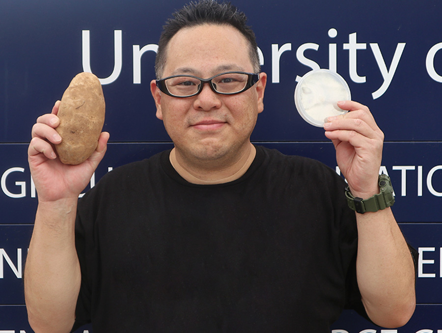 Masaki Shimono holding up a potato and treatment. 