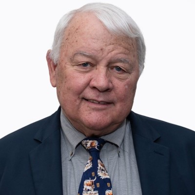 Dr. Thomas Harris poses in front of a white background