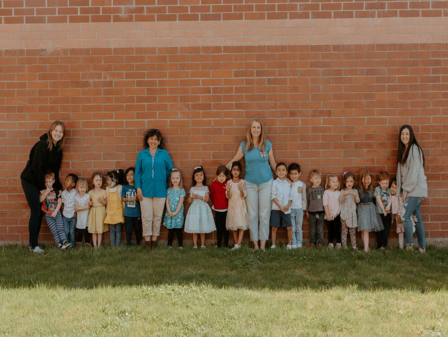 Preschool children standing with their teachers