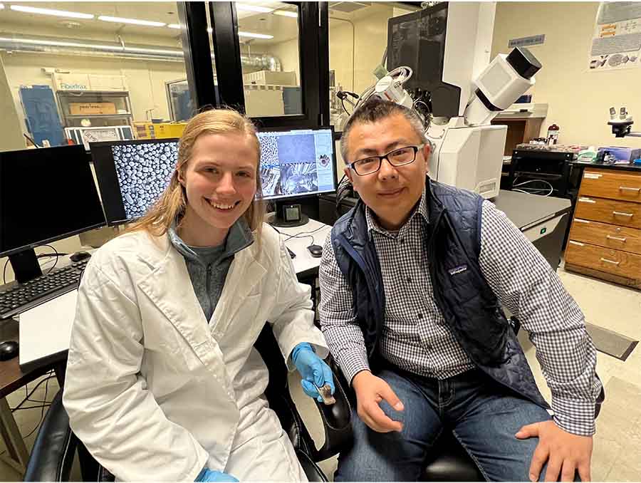 Photo of student Sydney Fields and Professor Yufeng Zheng seated in a lab.