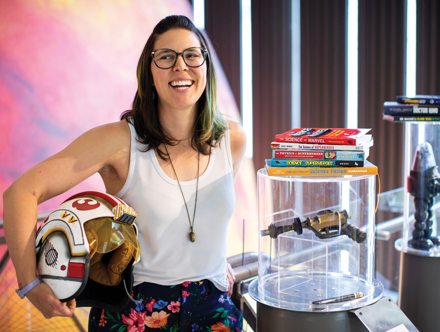 Lauren Sankovitch surrounded by Marvel Universe books and objects on display