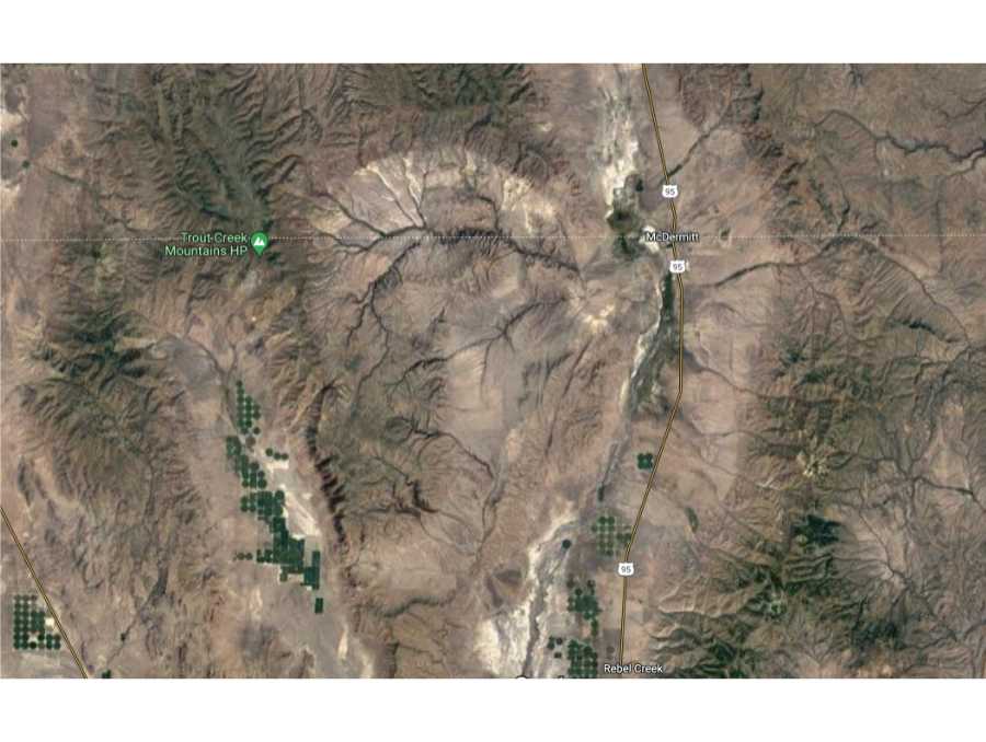 An aerial view of the McDermitt Caldera shows a visible depression in the landscape in the shape of a lightbulb.