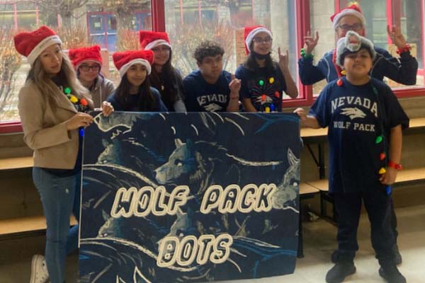 Wolf Pack Bot Team in holiday hats holding a banner