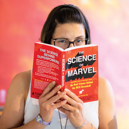 Lauren Sankovtich holding a book titled "The Science of Marvel"