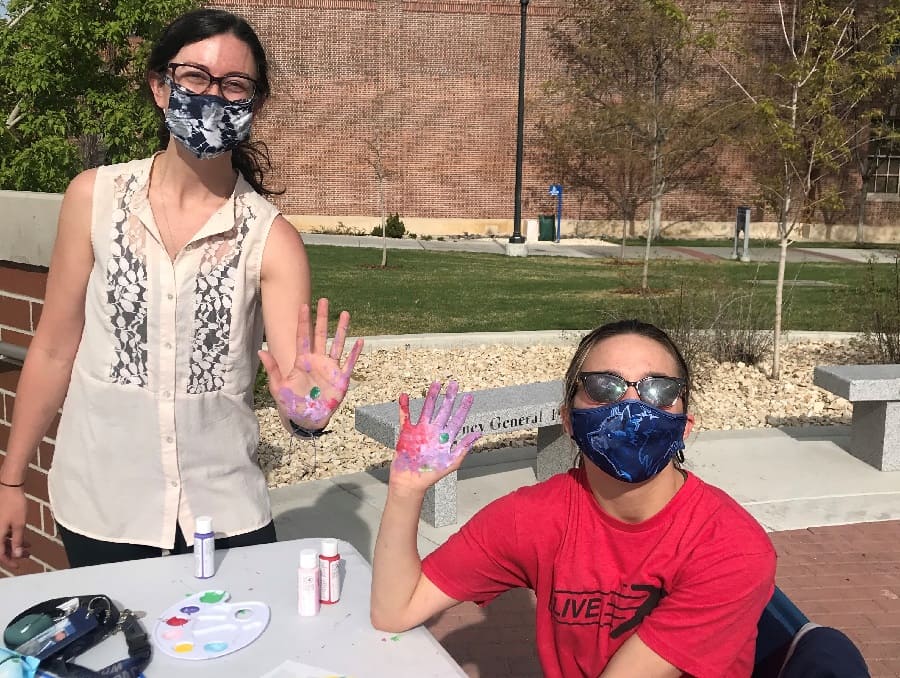 Callie Whitsit and Autumn Cuellar finger painting at a 2021 art therapy workshop 