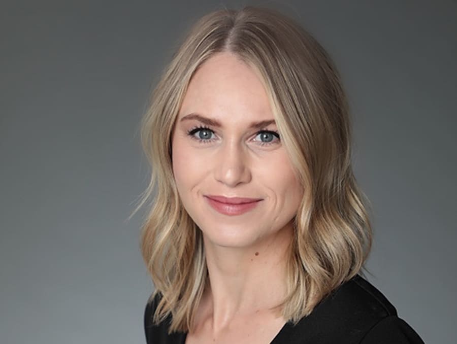 A close-up headshot of Katie Hutchings in front of a grey background