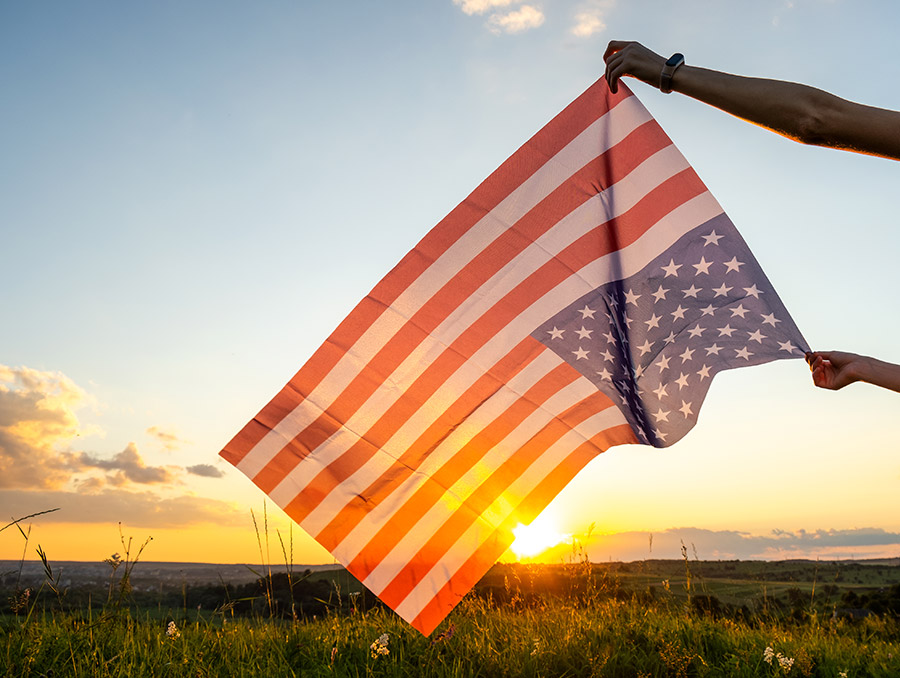 United States flag held upside down at dusk