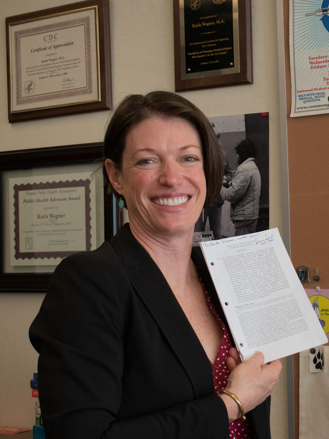 Karla Wagner holding a copy of the legislation she was involved in, signed by then-Governor Brian Sandoval.
