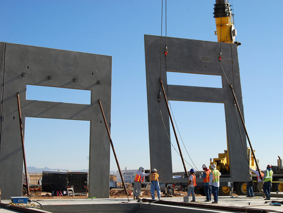 Construction workers erect concrete building frames.