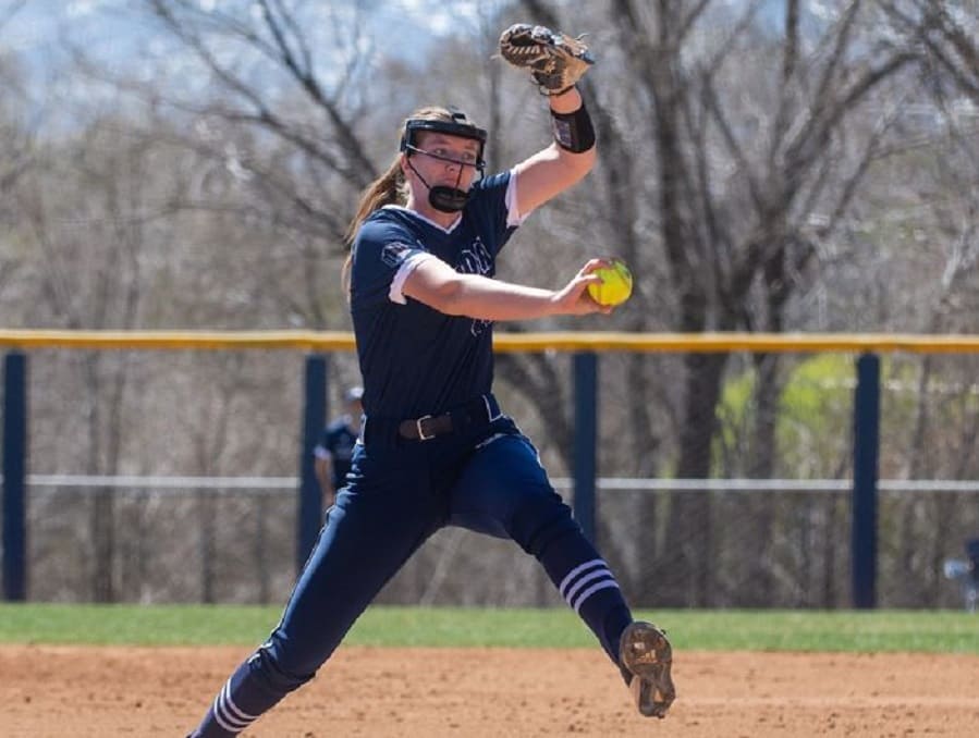 A softball player winding up for a throw