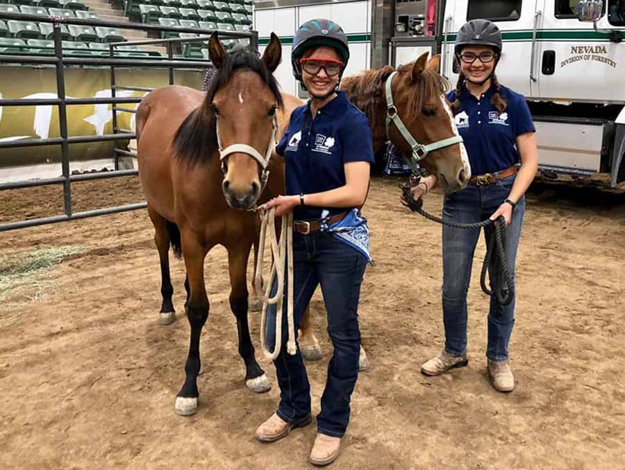 Two 4-H youth standing with their horses. 