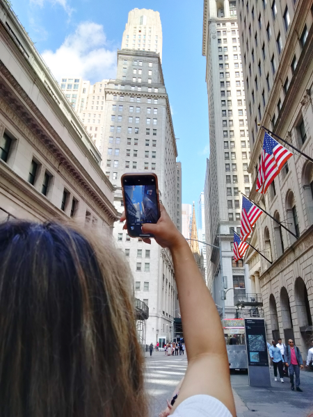 Student takes photograph of New York scenery using her cellphone.