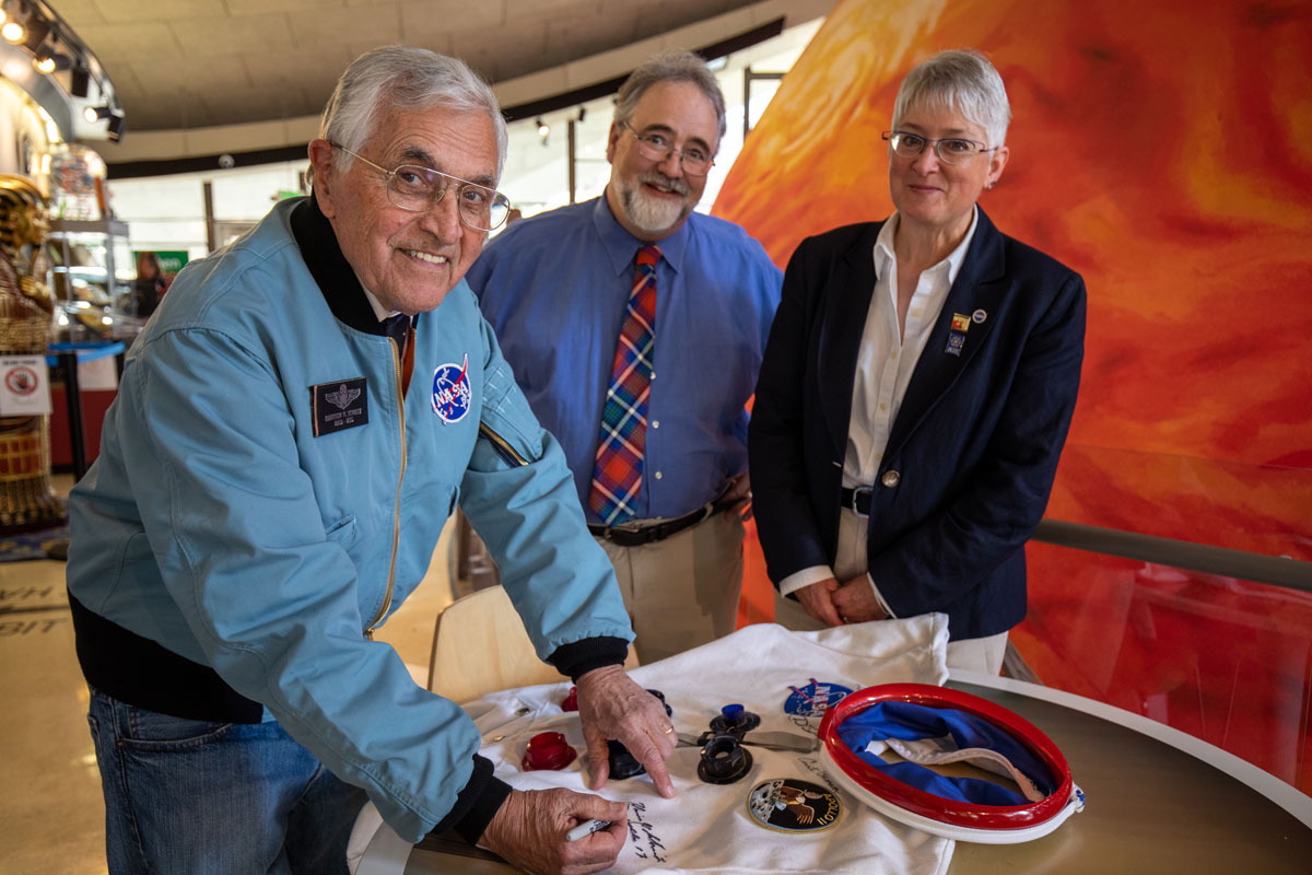 Harrison Schmitt signs a space suit in the Fleischmann Planetarium