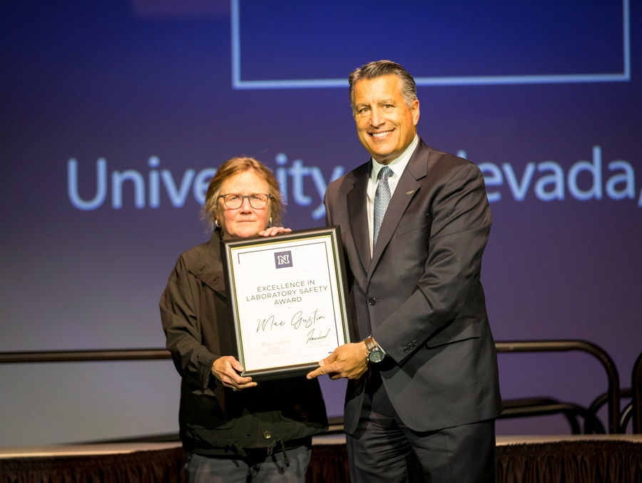 President Sandoval and Mae Gustin holding Excellence in Laboratory Safety Award plaque