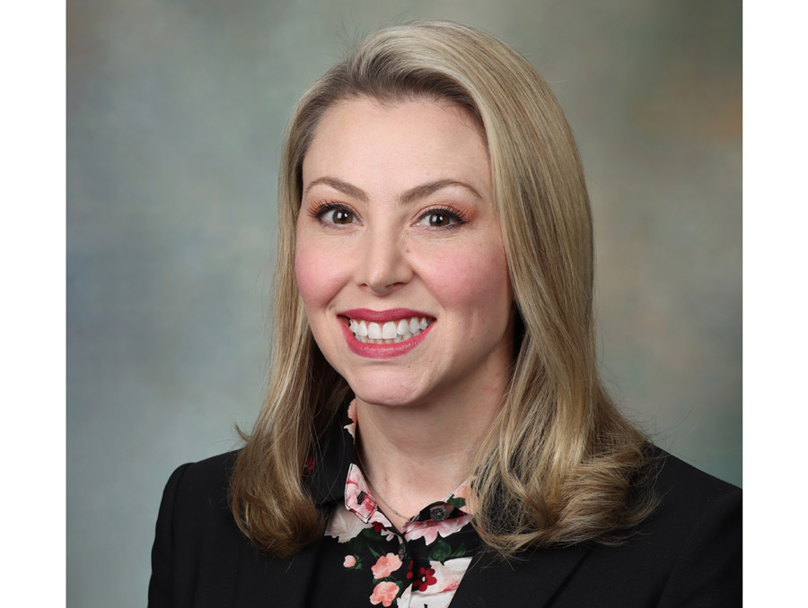 Lisa LeMond smiles, wearing a black jacket over a floral print shirt.