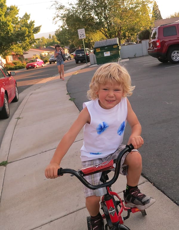 Zizou Colombant rides his bike on a sidewalk.