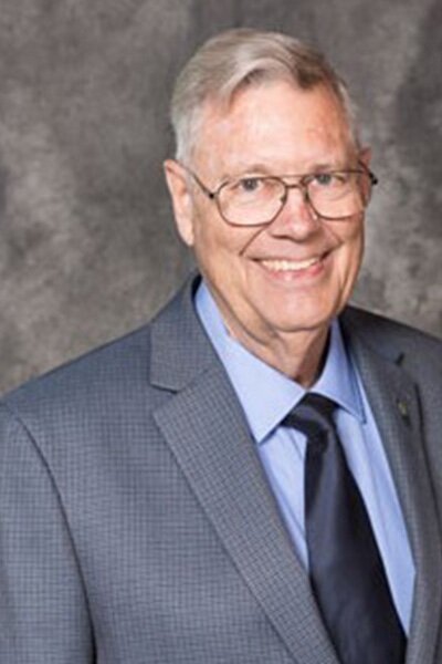 Photo of Larry Struve. Man wearing grey sport coat with light blue shirt and dark blue tie. 