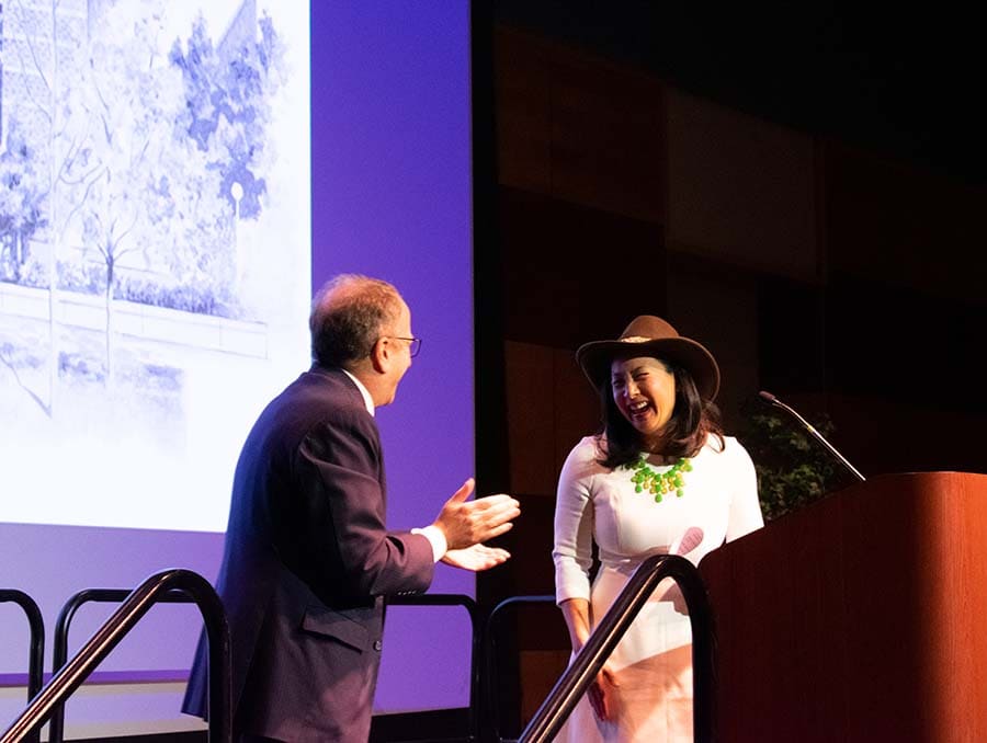 Reynolds School of Journalism Dean Alan Stavitsky stands next to Kristen Go as she smiles while wearing the cowboy hat.