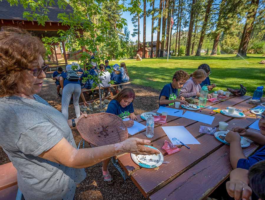 Adult chaperone guiding youth through an activity. 