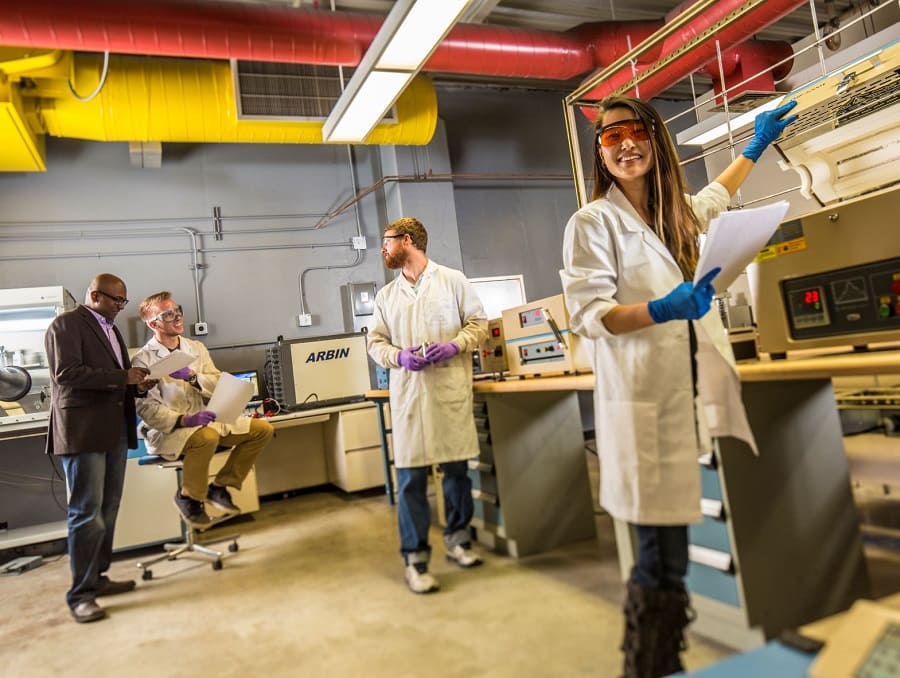 A professor with students in a technology lab