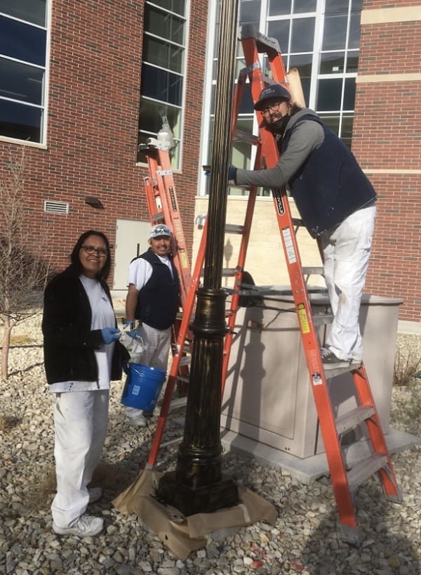 Becky Yazzie, Oscar Martinez, and Richard Favre working on a campus light pole