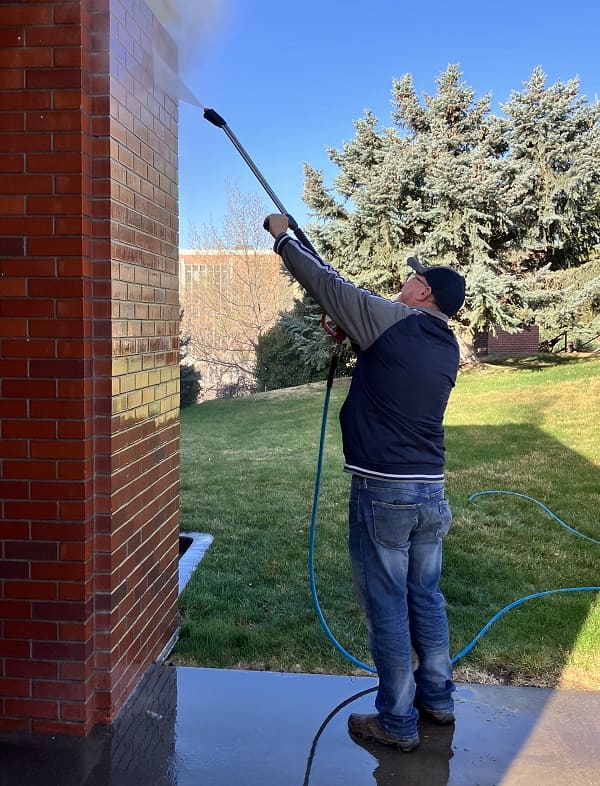 Clyde Carmack powerwashing a brick exterior