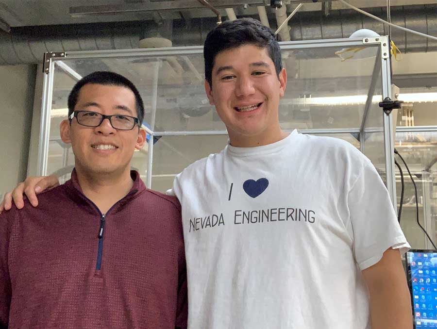 Yifei Jin and Erick Bandala stand in a lab facing camera.