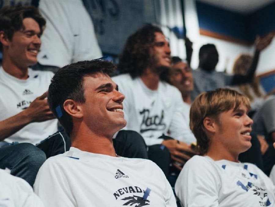 Men's tennis team seated at an event