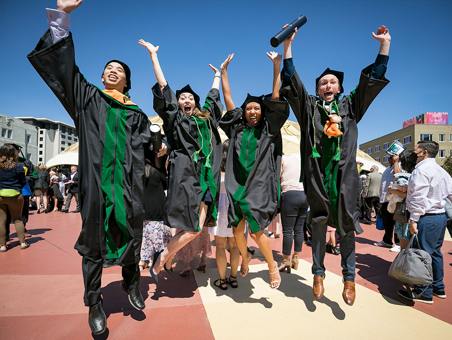 Students jumping for joy at the 2022 hooding ceremony