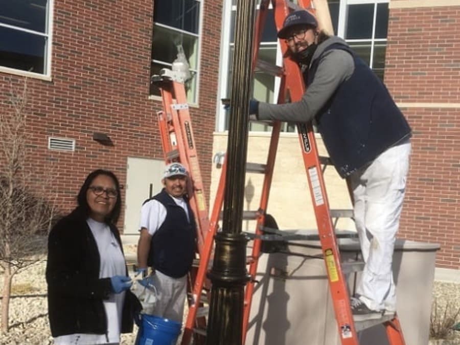 Becky Yazzie, Oscar Martinez, and Richard Favre working on a campus light pole