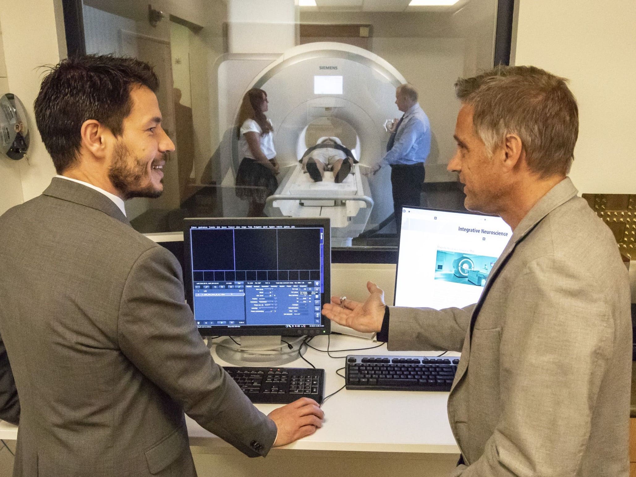 A representative of Siemens and the University's neuroscience imaging director confer as an fMRI is conducted.