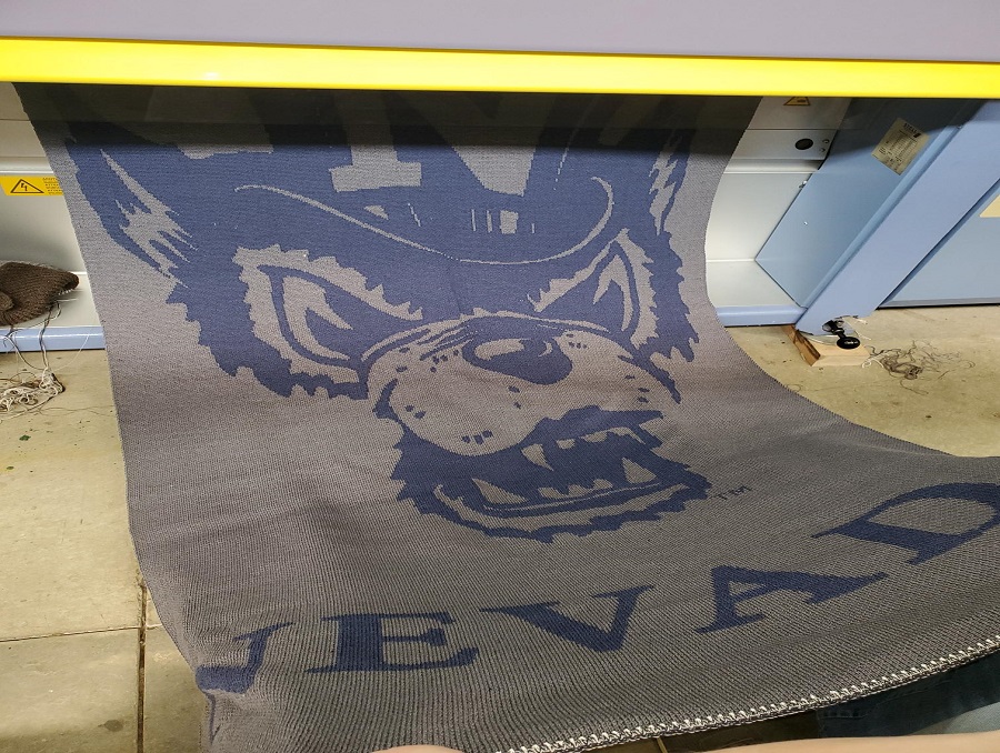 A Nevada Wolf Pack blanket with the word "Nevada" on the edge, made of the University’s Rafter 7 wool rolls.