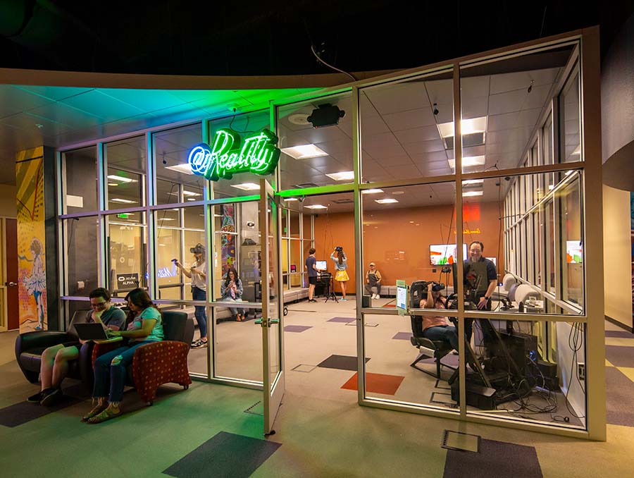 The @Reality lab, with multiple people using VR headsets and enjoying the space.