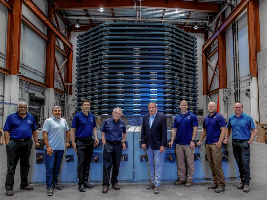8 faculty members stand in front of the Soil Box System in the Large-Scale Structures Laboratory.