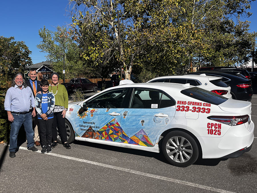 Mike Kazmierski, Jean-Paul Perrotte, Brett Van Hoeson, and Emile Perrotte standing next to a taxicab featuring Emile's artwork.