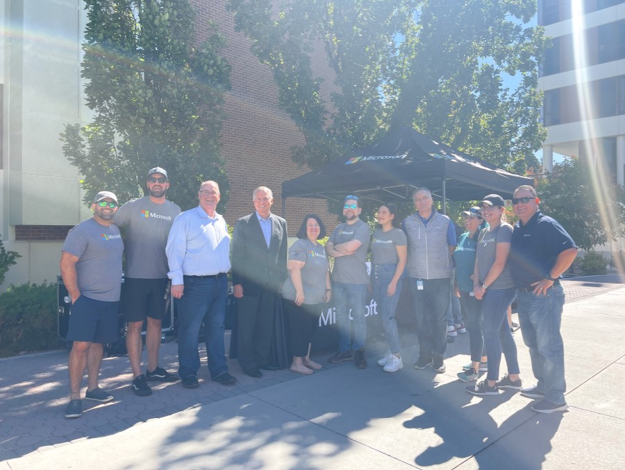 Microsoft employees stand with staff from the College of Business at the kickoff BBQ